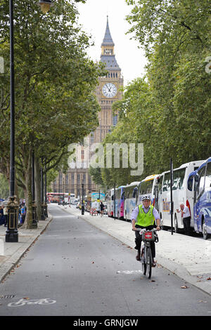 Ein Radfahrer auf einem gemieteten 'Boris' bike verwendet London's neuen Radweg am Victoria Embankment getrennt. Zeigt Big Ben im Hintergrund. Stockfoto