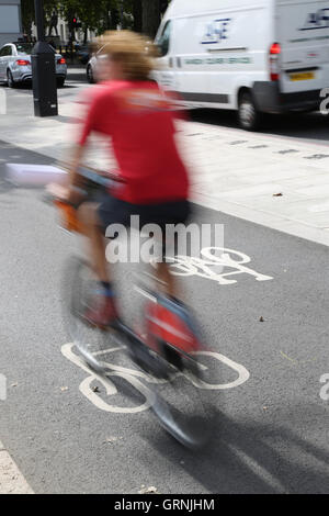 Ein Radfahrer (verschwommen durch Geschwindigkeit) auf Londons neue, Super-Autobahn am Victoria Embankment Radfahren. Fahrrad fahren gemieteten "Boris" Stockfoto