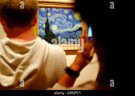 Besucher die Fotos von "Sternennacht" von Vincent Van Gogh im Museum of Modern Art (MoMA). Manhattan, New York City, USA Stockfoto