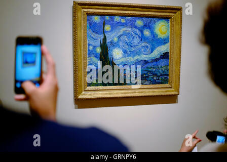 Besucher die Fotos von "Sternennacht" von Vincent Van Gogh im Museum of Modern Art (MoMA). Manhattan, New York City, USA Stockfoto