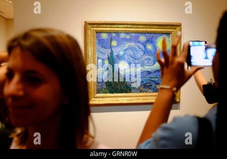 Besucher die Fotos von "Sternennacht" von Vincent Van Gogh im Museum of Modern Art (MoMA). Manhattan, New York City, USA Stockfoto