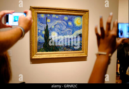 Besucher die Fotos von "Sternennacht" von Vincent Van Gogh im Museum of Modern Art (MoMA). Manhattan, New York City, USA Stockfoto