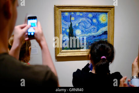 Besucher die Fotos von "Sternennacht" von Vincent Van Gogh im Museum of Modern Art (MoMA). Manhattan, New York City, USA Stockfoto