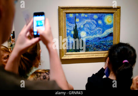 Besucher die Fotos von "Sternennacht" von Vincent Van Gogh im Museum of Modern Art (MoMA). Manhattan, New York City, USA Stockfoto