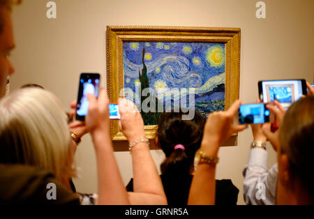 Besucher die Fotos von "Sternennacht" von Vincent Van Gogh im Museum of Modern Art (MoMA). Manhattan, New York City, USA Stockfoto