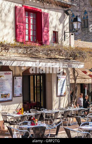 CARCASSONNE, Frankreich - 1. April 2011: Touristische Paare, die in der Nähe von Tischen und Stühlen der Straße restaurant Stockfoto