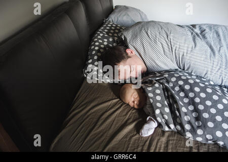 Neugeborenes Baby Boy Schlaf mit seinem Vater Stockfoto