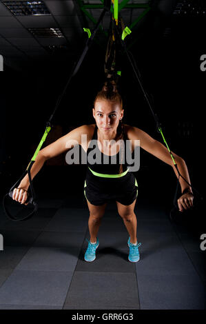 Frauen tun Push ups Training Arme mit Trx-Fitness-Riemen in der Turnhalle Konzept Training Gesundheit Sport Stockfoto