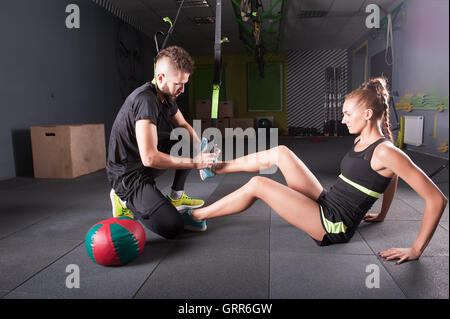 der Coach hilft das Mädchen zur Tätigung Riemen Stockfoto