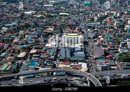 Die Metro Manila Skyway in den Vordergrund und verschiedenen Häusern und Gebäuden im Hintergrund, Manila, Philippinen. Stockfoto