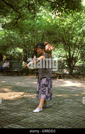 Chinesische Frau praktizieren Tai Chi Chuan in Xiang Yang Park, Shanghai, China Stockfoto