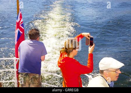 Touristen genießen Sie eine Kreuzfahrt und Fotografieren an Bord das Heck des Ullswater Steamers M.V Western Belle. Ullswater, Penrith Stockfoto