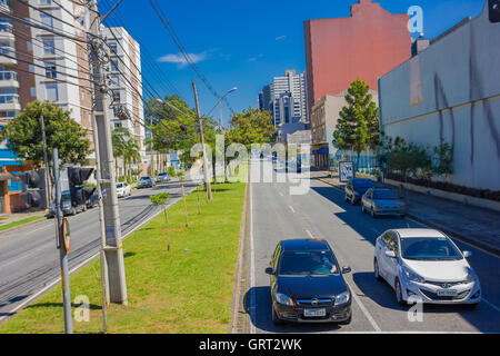 CURITIBA, Brasilien - 12. Mai 2016: zwei Autos warten an der Kreuzung, Kabel Post befindet sich in dem mittleren Bürgersteig Stockfoto