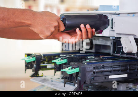 Closeup Hand vor offenen Kopierer während der Wartung Reparaturen mit Werkzeug "handheld" schwarz mechanische Teile Stockfoto