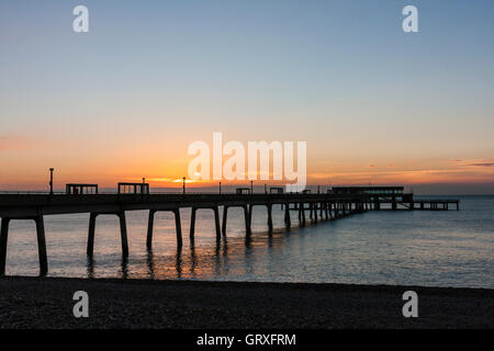 Dämmerung Himmel über den Ärmelkanal und Pier an der Küste von Kent in England. Sehr ruhiges Meer mit dünnen Band von Orange im Himmel am Horizont. Stockfoto