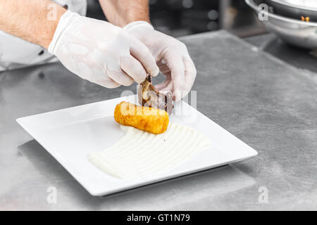 Lamm-Rippen auf weißen Teller serviert mit gestampften Kartoffeln gefüllte Kroketten Stockfoto