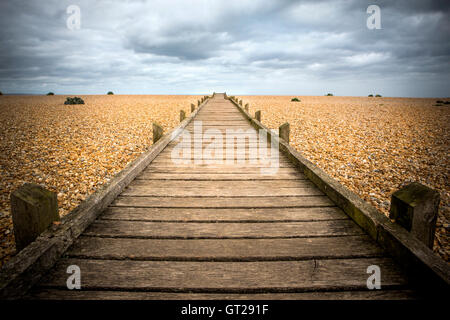 Ein Holzsteg auf einem Kiesstrand Stockfoto