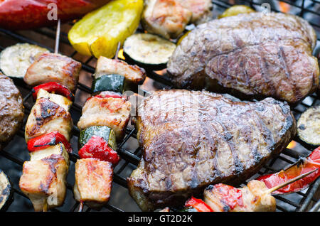 Fleisch mit Gemüse kochen am Grill mit Flammen. Stockfoto