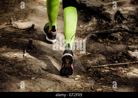 Mädchen läuft einen Marathon Stein Weg. Closeup Beine Kompressionsstrümpfe und Laufschuhe Stockfoto