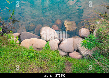 Felsen am Ufer Flusses Stockfoto