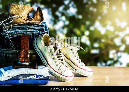 Kleidung und Schuhe auf einem hölzernen mit natürlichem Licht. Stockfoto