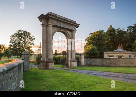 Blick auf den Sonnenuntergang von der imposanten Triumphbogen am Eingang und Zufahrt zum Duncombe Parkgrundstück, North Yorkshire, England. Stockfoto