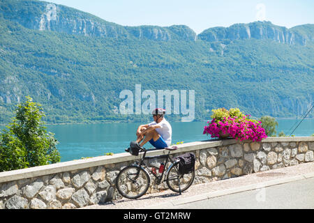 Männliche Radfahrer entspannen / ruhen beim touring / Reiten in Conjux, auf / neben See du Bourget (Lac Du Bourget) in Savoyen, Frankreich. Stockfoto