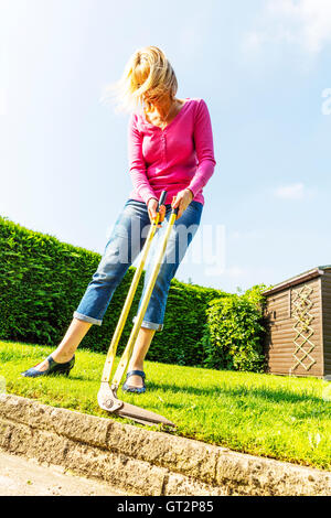 Mäht Rasen mit langstieligen Scheren Scheren trimmen Rand Frau Gartenbau Gärtner Hecke schneiden UK England GB Einfassung Stockfoto