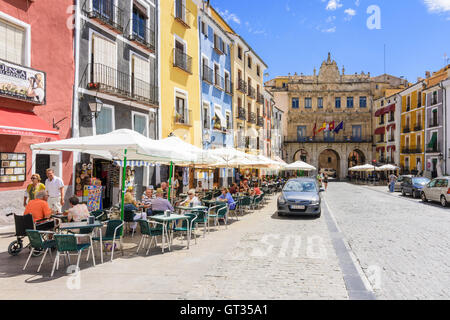 Cafés unter den bunten Gebäuden des Plaza Mayor mit Blick auf das barocke Rathaus, Cuenca, Castilla La Mancha, Spanien Stockfoto