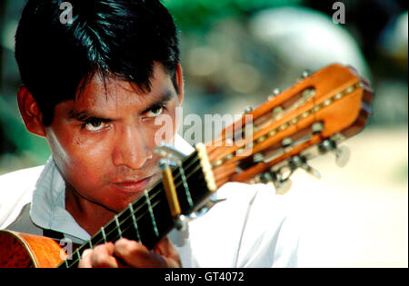 Eine Mariachi singt und spielt Gitarre in der Zocalo, Oaxaca-Stadt, Mexiko Stockfoto