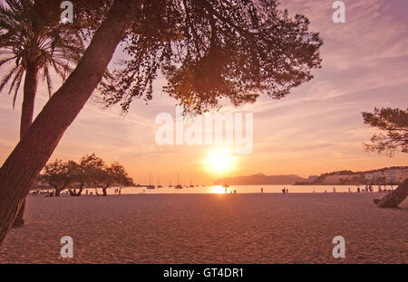 Beleuchtete Silhouette Figuren am Strand an einem sonnigen Sommerabend bei Sonnenuntergang in Mallorca, Balearen, Spanien. Stockfoto