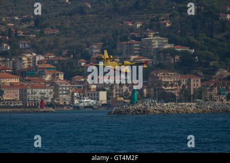 Imperia, Italien. 8. September 2016. Ein Wasser-Bombenflugzeuge Bombardier 415 (Canadair) nähert sich das Meer in der Nähe von Imperia (Italien) während einer Antenne Brandbekämpfung operation Stockfoto