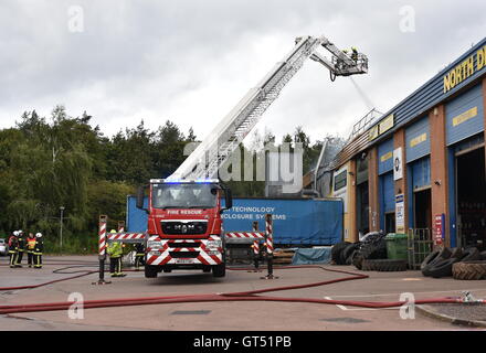 Devon, UK. 9. September 2016. Tiverton Feuer: Die Szene von einem Großbrand in den Räumlichkeiten des Warren Hughes Möbelhersteller in Ormidale Square, Tiverton Business Park, Devon, am 16.00 BST auf Freitag, 9. September 2016. Die Feuerwehr wurden bei 11,23 genannt. Fünf Stunden waren später mindestens 6 Feuerlöschfahrzeuge noch am Tatort, darunter zwei Hebebühnen. Personal in den benachbarten Einheiten wurden auch unter anderem die Räumlichkeiten der North Devon Reifen und nationalen Reifen & Autocare evakuiert. Bildnachweis: Tim Squires/Alamy Live-Nachrichten Stockfoto