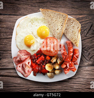 Traditionelles englisches Frühstück - Spiegeleier, Würstchen, Speck und Bohnen. Stockfoto