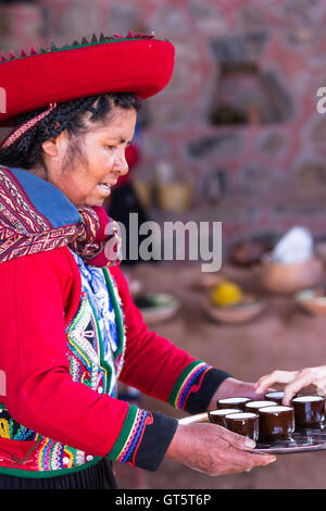 Chinchero Peru-Mai 18: Native Cusquena Frau gekleidet in bunten Trachten Coca Tee servieren. 18. Mai 2016, Chinchero Stockfoto