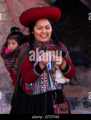 Chinchero Peru-Mai 18: Native Cusquena Frau gekleidet in bunten Trachten erklären den Vorgang des Webens mit ihr Stockfoto