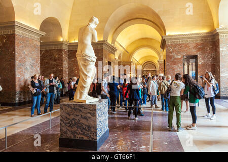 PARIS, Frankreich - 8. April 2011: Besucher, die im Inneren des Louvre-Museums in der Nähe von Statue der Venus von Milo Stockfoto
