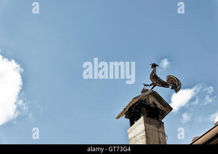 Ein altes Huhn Metall Wetterfahne oder Wetterhahn auf dem Dach mit schönen blauen Himmel und Exemplar Stockfoto