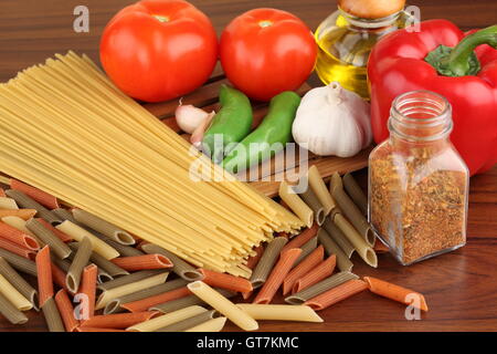 Pasta Zutaten. Cherry-Tomaten, Spaghetti Nudeln, Rosmarin und Gewürze auf einem Graphit Stockfoto