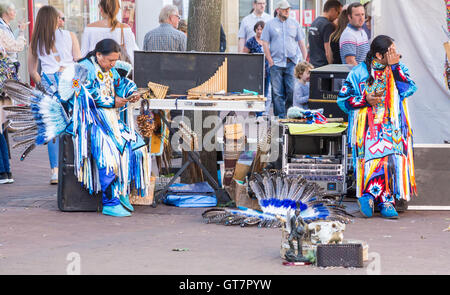 Musiker im traditionellen indianischen Kleid mit ihren Smartphones, Market Place, Carlisle, Cumbria, England Stockfoto