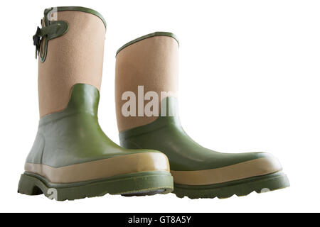 Spaß breiten flachen Winkel Blick auf ein paar robuste grüne und Beige wadenhohen Gartenarbeit Stiefel mit schweren Sohlen isoliert auf weiss Stockfoto