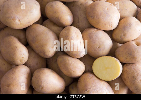 Full-Framehintergrund ganz Golden Kartoffeln mit einem Schnittfläche halben in der unteren rechten Ecke Stockfoto