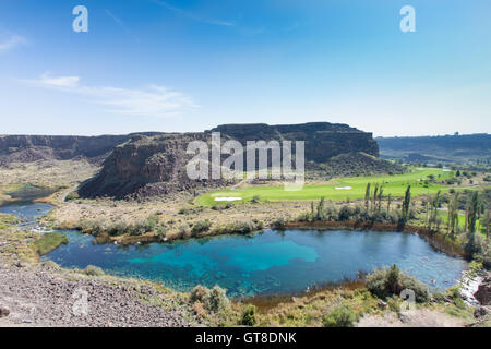 Warme Quellen und ruhigen blauen See, Jerome, Idaho mit üppigen grünen Ackerland im Tal zwischen schroffen Gipfeln in einer sce Stockfoto