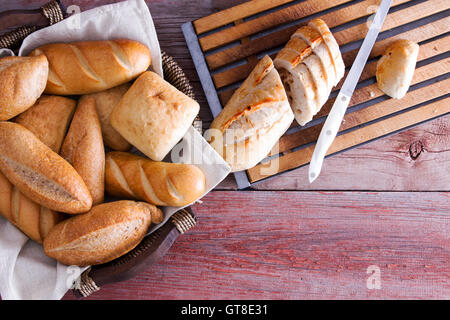 In Scheiben geschnittene Baguette und frische knusprige golden Brötchen in einem Weidenkorb auf einem Buffet-Tisch als Beilage zu din servierbereit Stockfoto