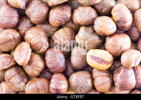 Full-Frame Hintergrundtextur von frische ganze geröstete Kastanien nach einem gesunden, saisonalen Herbst Snack oder für den Einsatz in der Küche Stockfoto