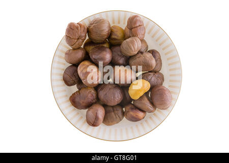 Frische geschälte oder geschälte ganze Kastanien auf einer Platte für einen leckeren saisonalen Herbst Snack, vor einem weißen Hintergrund Stockfoto