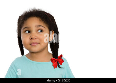 Schließen Sie neugierig vier Jahre alte African American Mädchen suchen auf der Seite vor weißem Hintergrund. Stockfoto