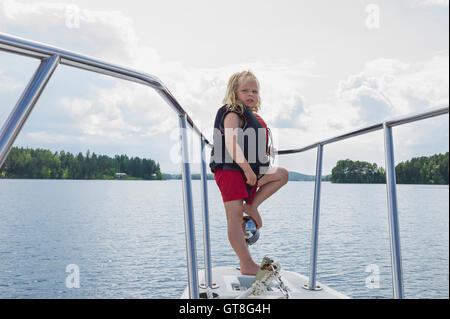 Junge stand auf der Nase des Bootes auf See, Schweden Stockfoto