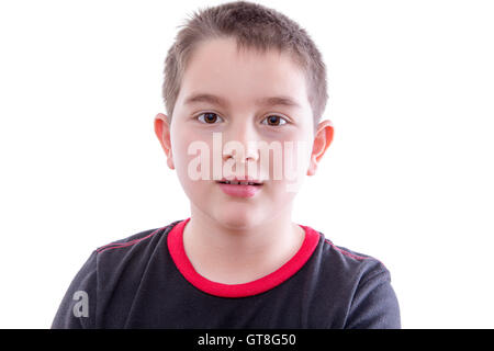 Kopf und Schultern enger, Porträt von Young Boy Blick in die Kamera mit leeren Ausdruck vor White Studio-Hintergrund Stockfoto