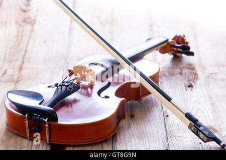 Nahaufnahme kleine Violine Musikinstrument für Kinder ruhen auf einem Holzfußboden. Stockfoto